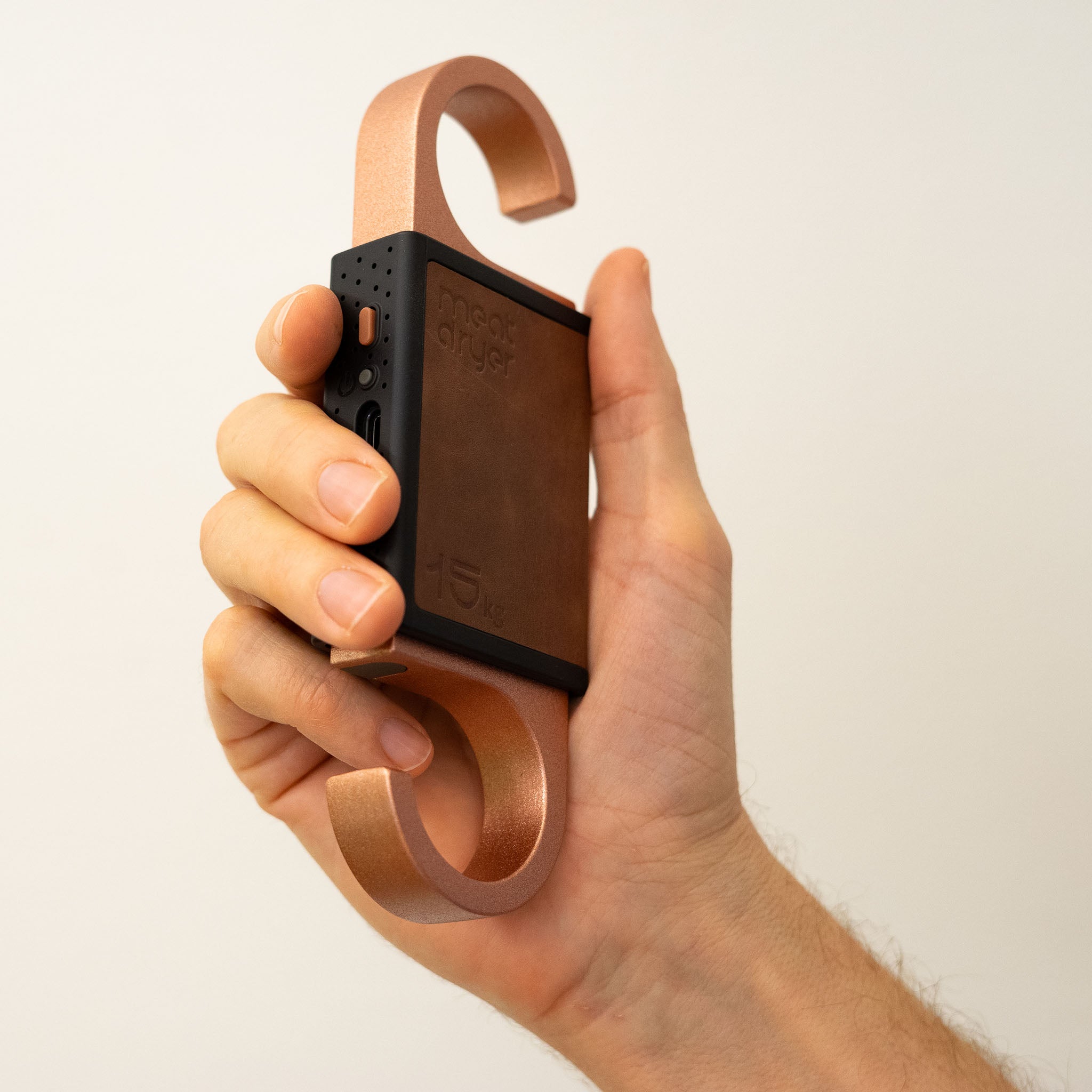 Hand holding a smart meet hook against a plain background