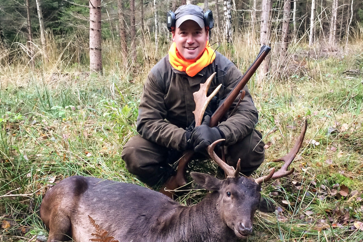 Hunter beside a deer taken in the forest, before gutting and butchering